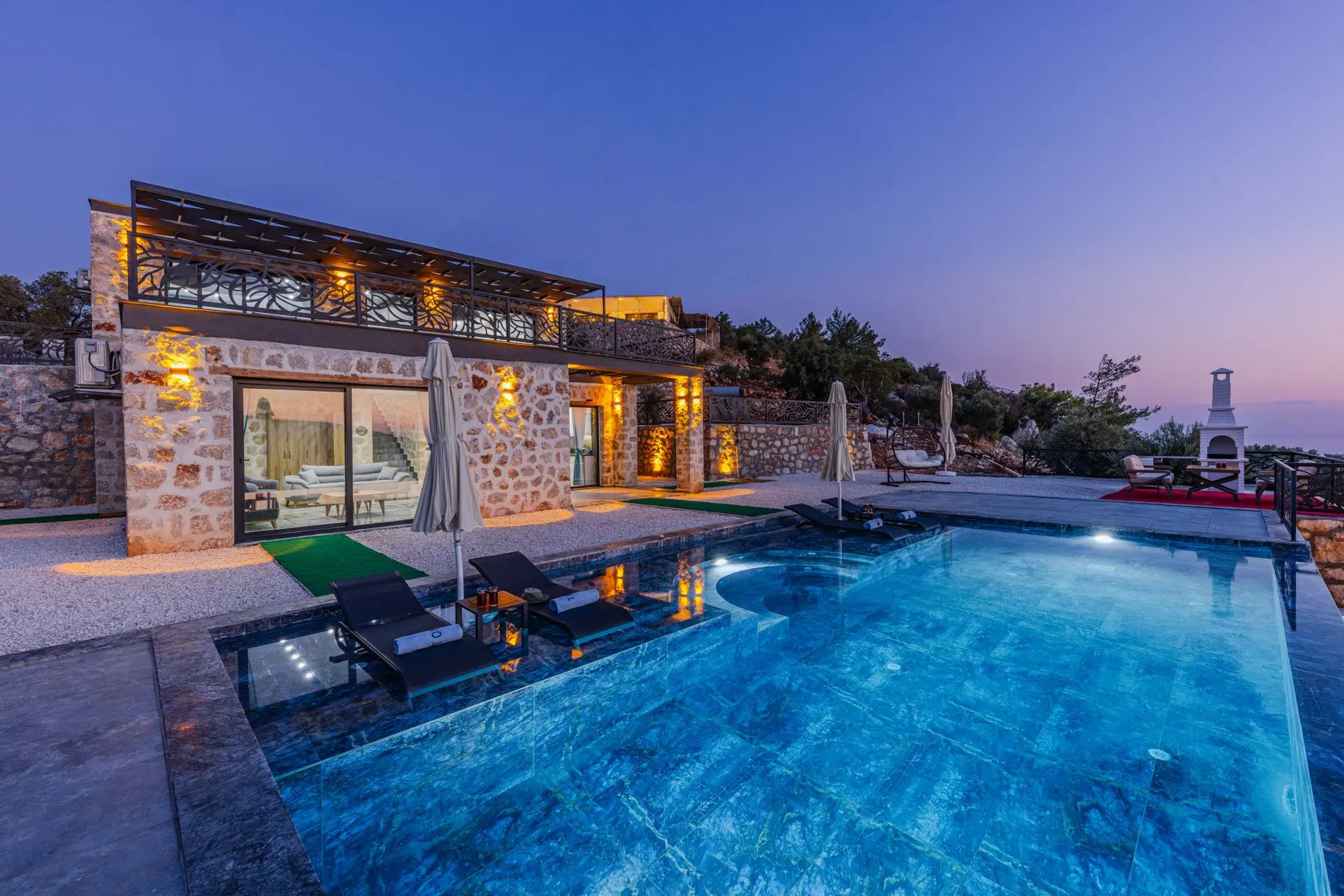 Villa de piedra con piscina al atardecer