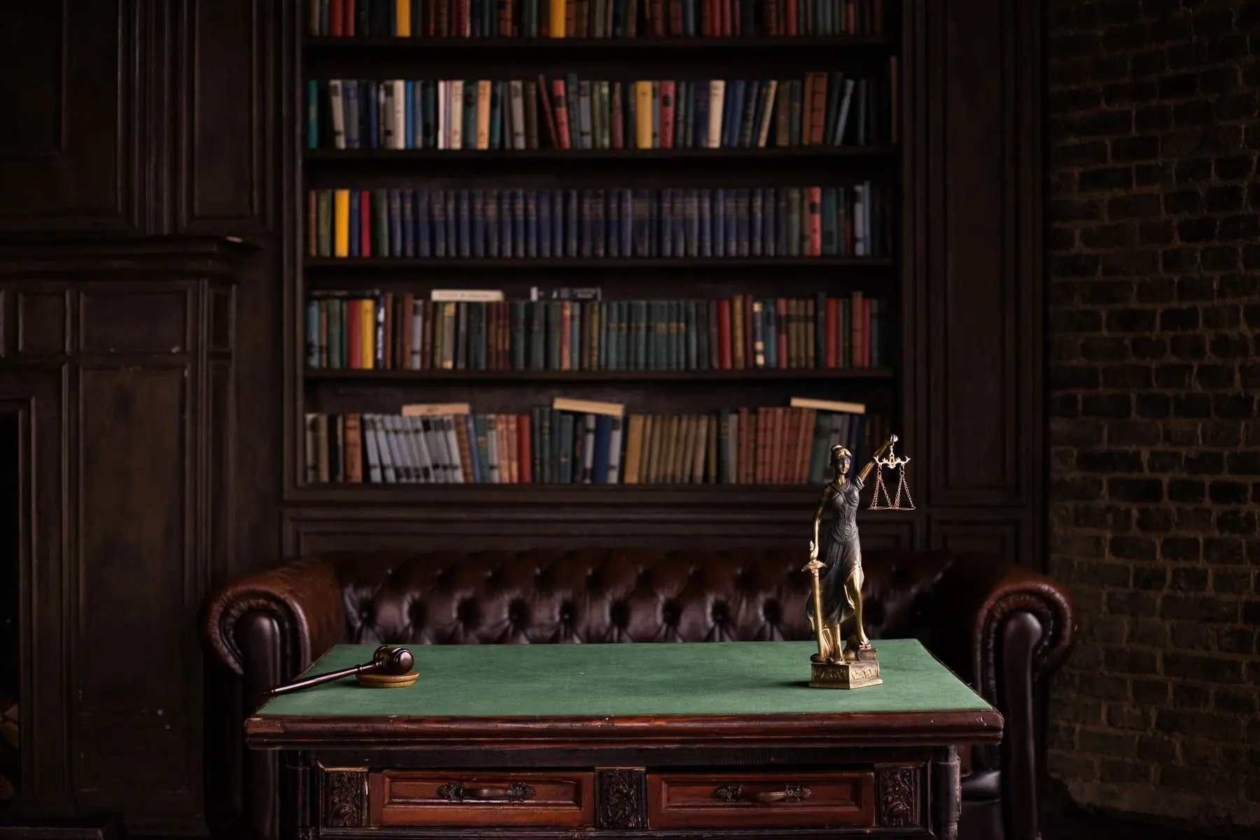 Biblioteca jurídica del estudio con sillón de cuero y balanza de la justicia